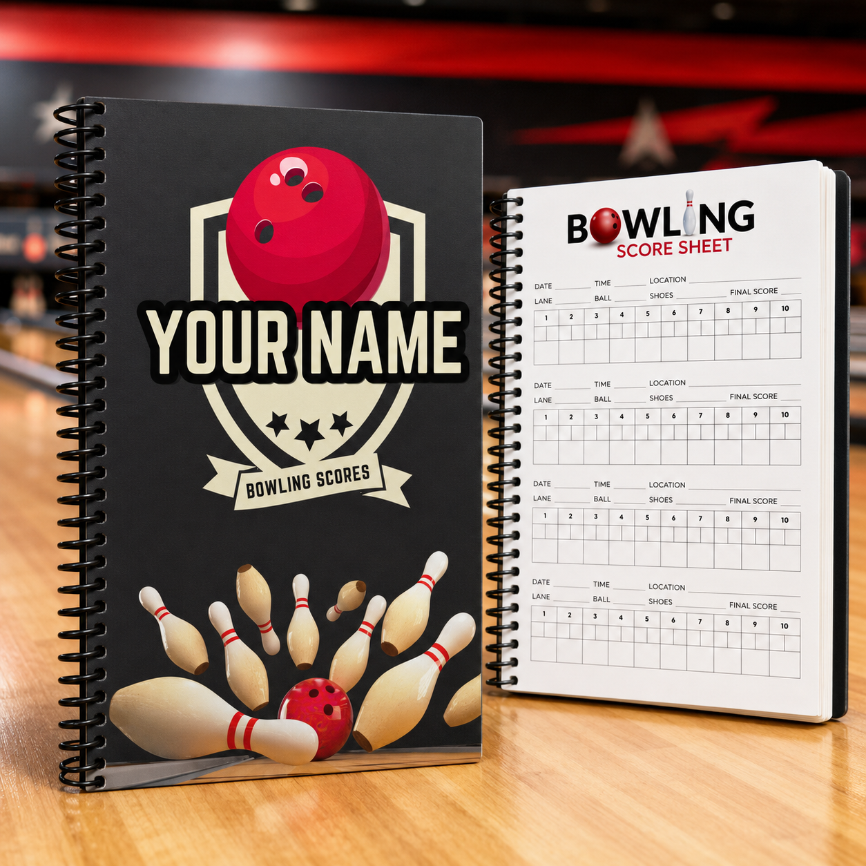 A black spiral-bound bowling notebook with a red bowling ball and pins graphic, shown next to an open white bowling score sheet on a wooden tabletop.